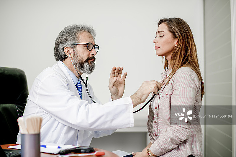 年轻女人接受医生检查胸部图片素材