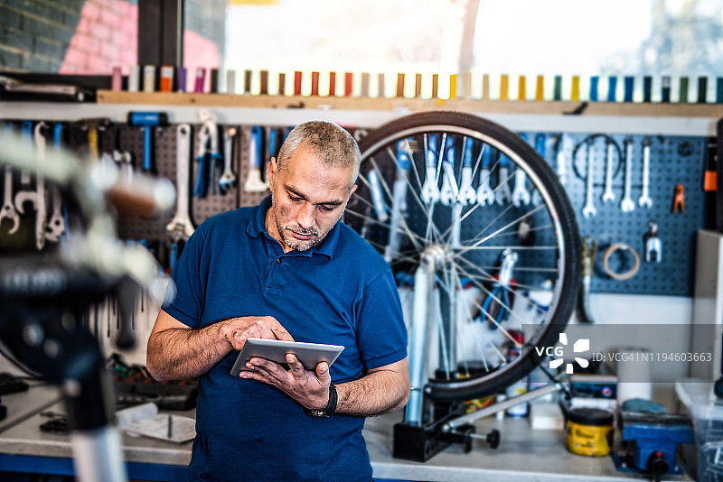 自行车技师在平板电脑上搜索自行车零件图片素材