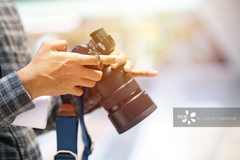 摄影师手持专业数码相机的特写图片素材