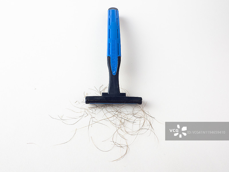 白色背景上刀片之间有毛发的蓝色一次性剃须刀特写图片素材