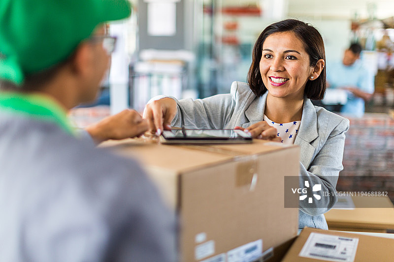 快递员从小型企业收取或派送包裹图片素材
