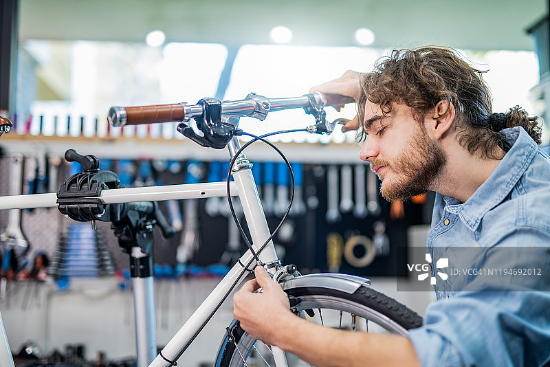 专注的机械师修理自行车刹车图片素材