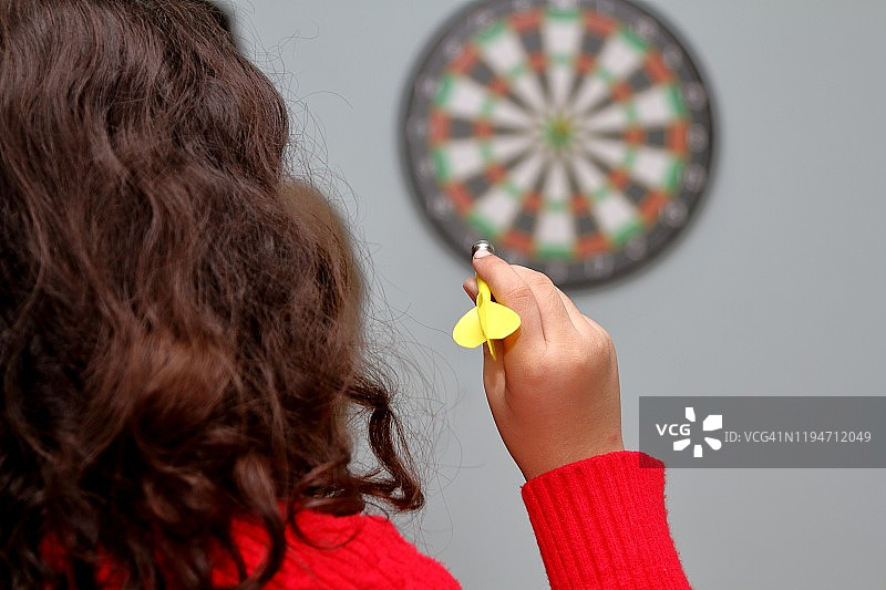 小女孩在房间里玩飞镖游戏图片素材