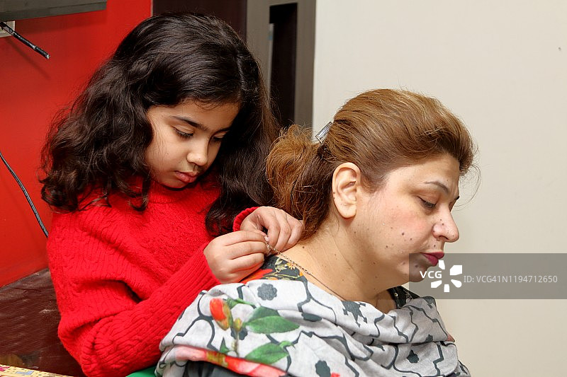 女儿给母亲戴项链图片素材