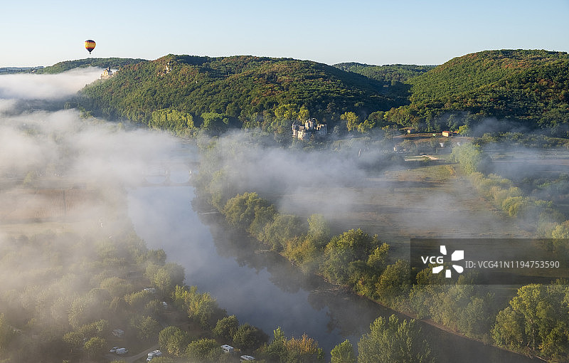 黎明时分多尔多涅河上的热气球和城堡山丘的航拍照片图片素材