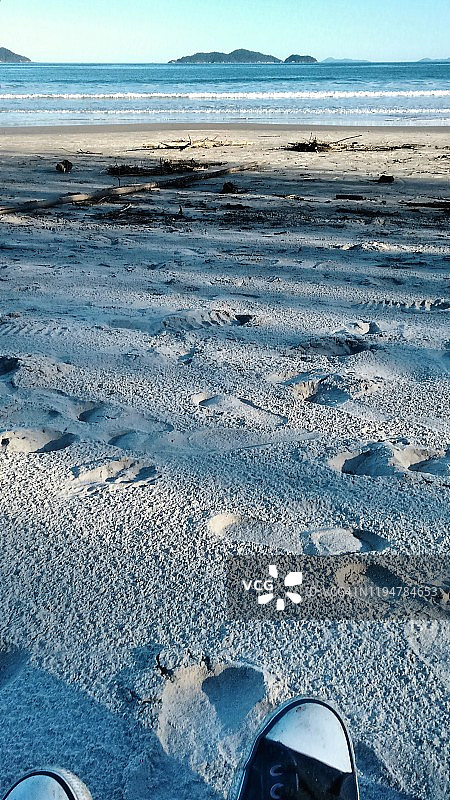 坐在巴西圣卡塔琳娜州弗洛里亚诺波利斯海滩沙滩上图片素材