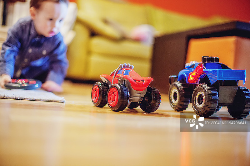 在家地板上玩玩具汽车的小男孩图片素材