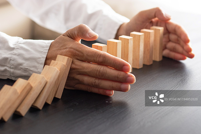 商人放置木块于积木塔，风险控制图片素材