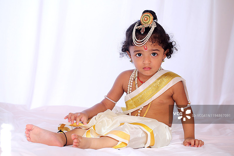 打扮成小克里希纳的可爱男孩特写图片素材