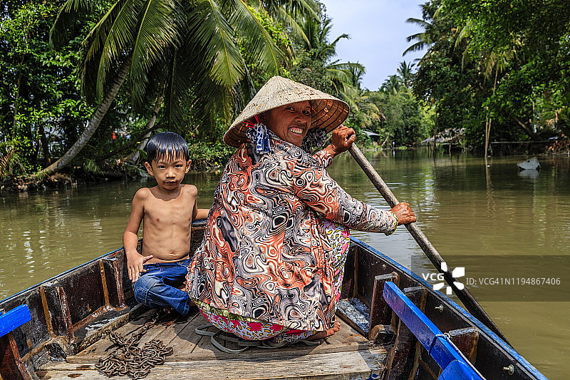 在越南湄公河三角洲划船的越南母亲图片素材
