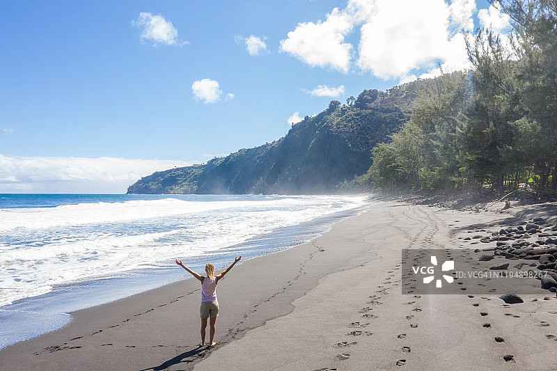 夏威夷海滩上张开双臂的女人航拍视角图片素材