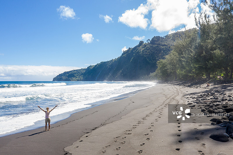 夏威夷海滩上张开双臂的女人航拍视角图片素材