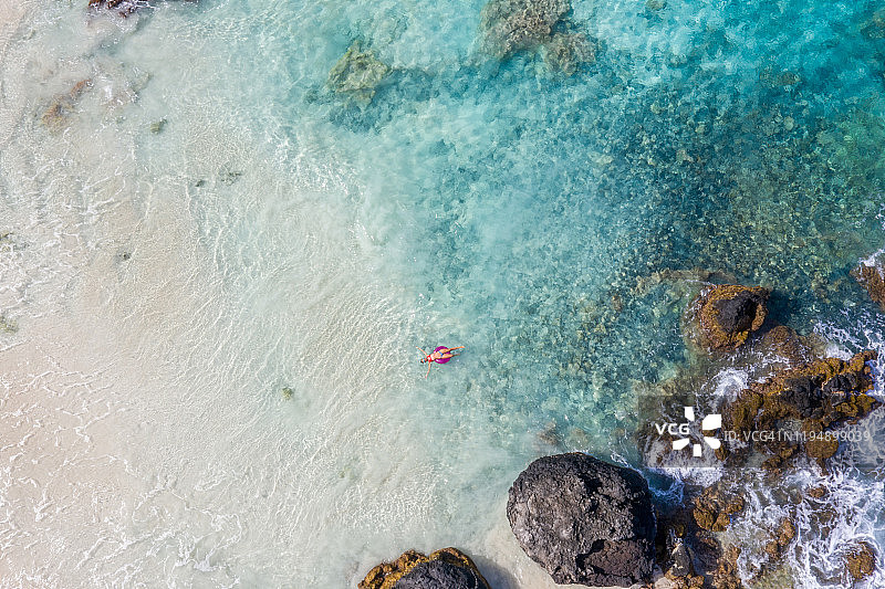 女子在海上使用充气泳圈放松身心航拍图片素材