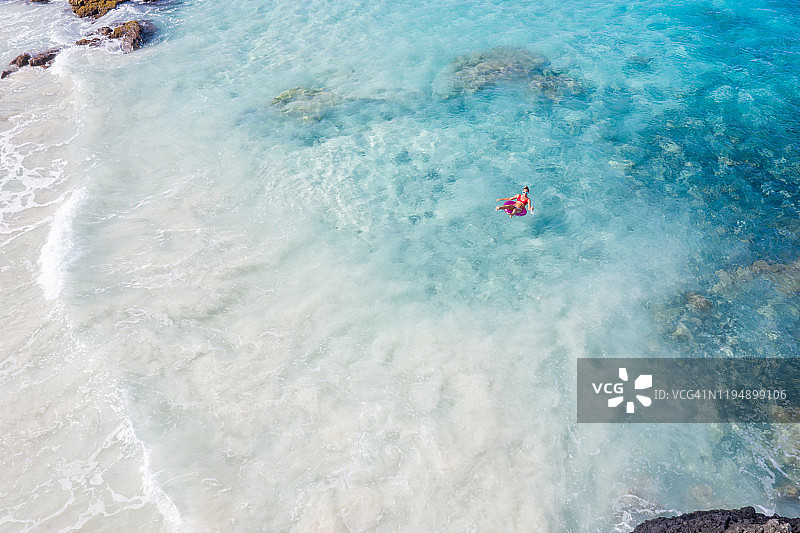 女子在海上使用充气泳圈放松身心航拍图片素材