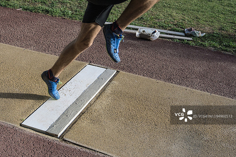男子准备跳远，脚踩起跳板图片素材