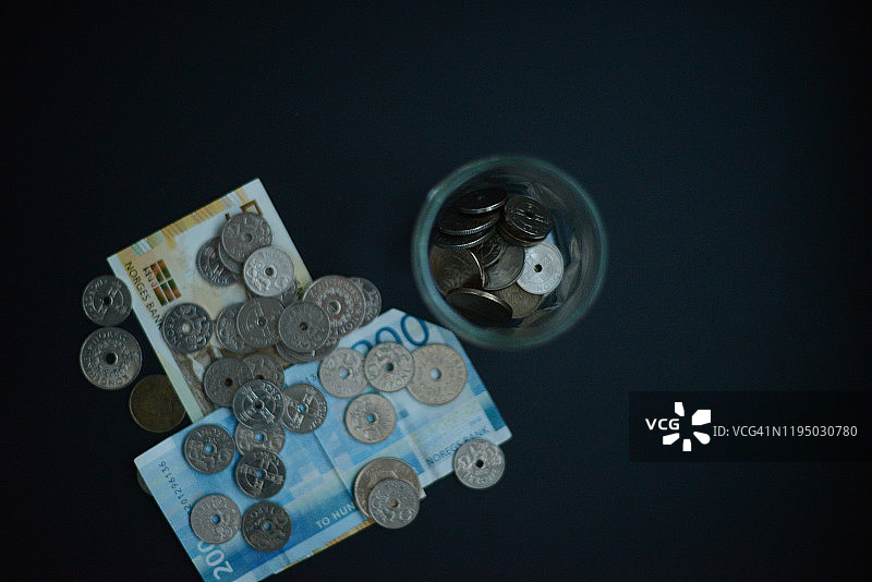 黑色背景下的硬币和纸币罐子图片素材