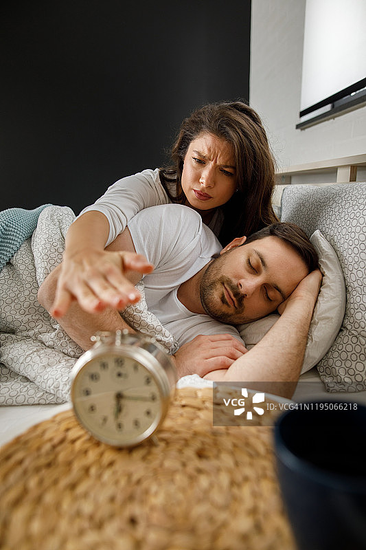 年轻女子关闭闹钟图片素材