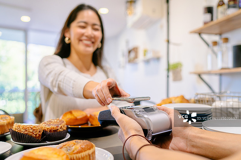 顾客在咖啡馆进行非接触式支付图片素材