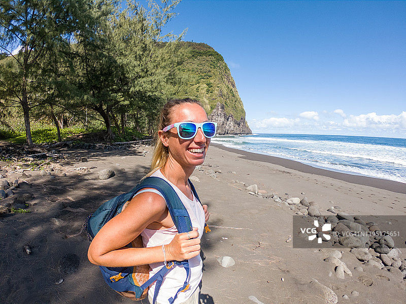 在夏威夷海滩眺望威庇欧山谷的徒步女子图片素材