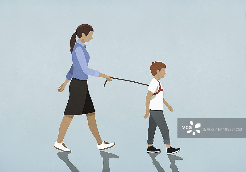 母亲牵着戴背带的儿子走路图片素材