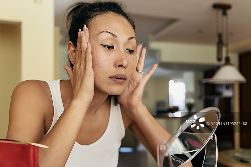 美丽的亚洲女性用双手紧致面部图片素材