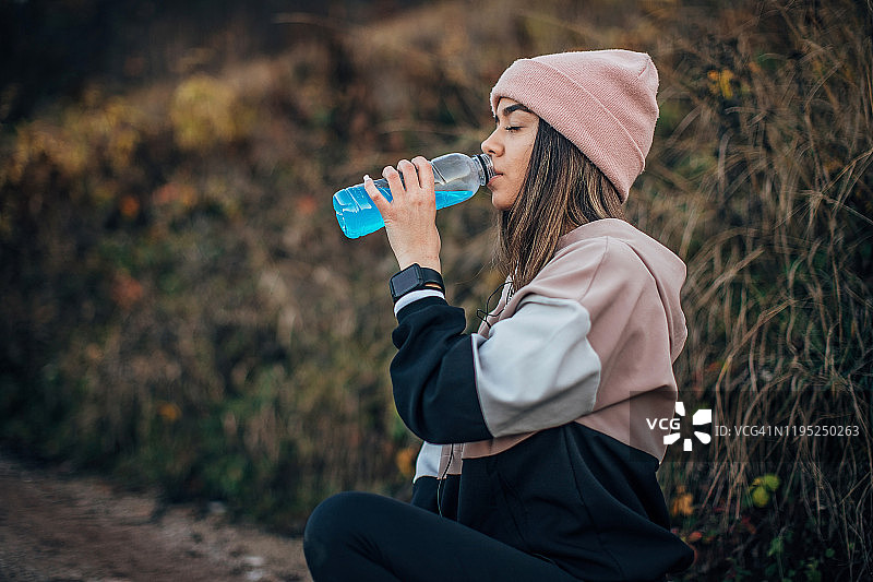 年轻女人在喝能量饮料图片素材