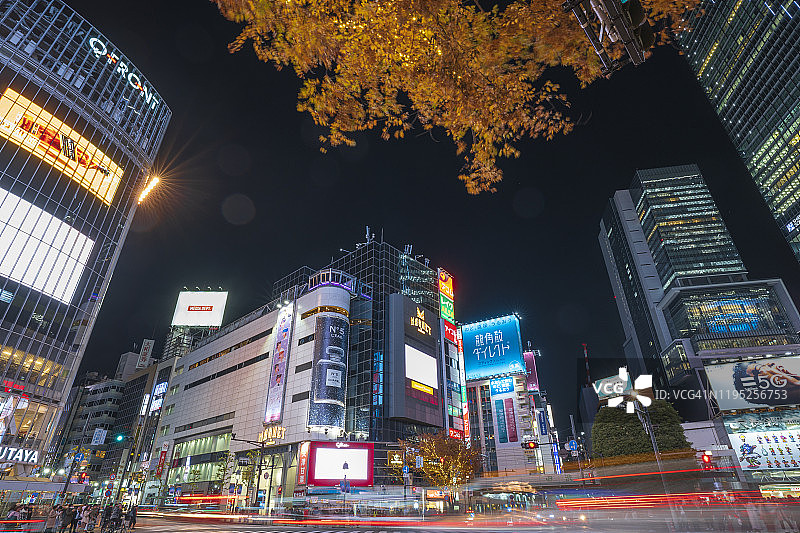 东京涩谷十字路口夜间交通和行人，有撑伞者图片素材