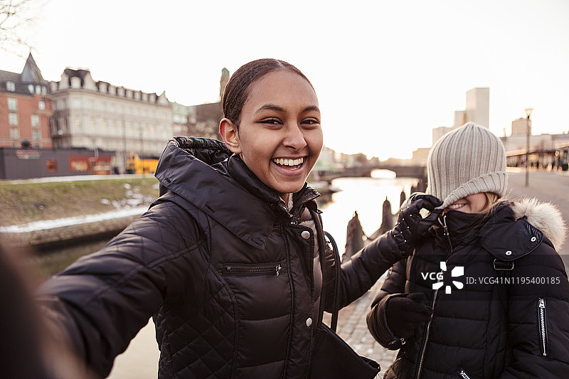 在城市里和朋友一起玩耍的快乐少女肖像图片素材