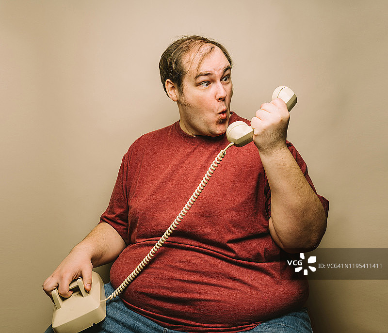 用老式电话做鬼脸的男人图片素材