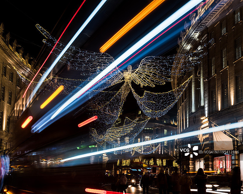 夜晚伦敦摄政街的圣诞灯饰、购物者和交通图片素材