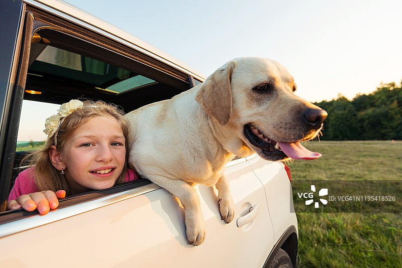 女孩和黄色拉布拉多犬的公路旅行图片素材