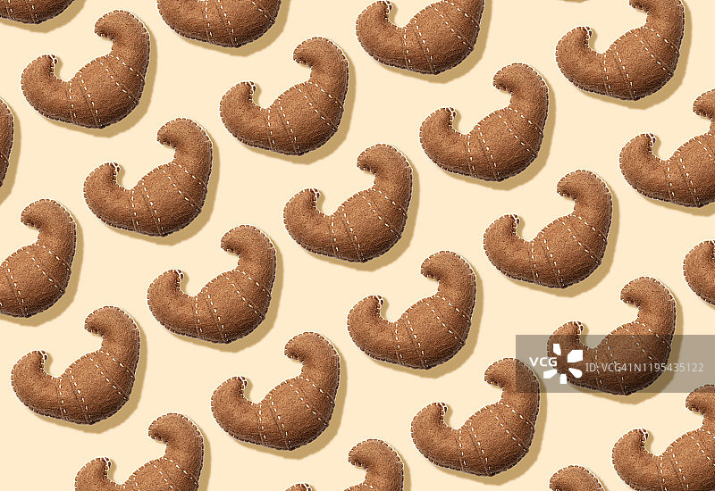 3D插画：奶油色背景上的毛绒假牛角面包图案图片素材