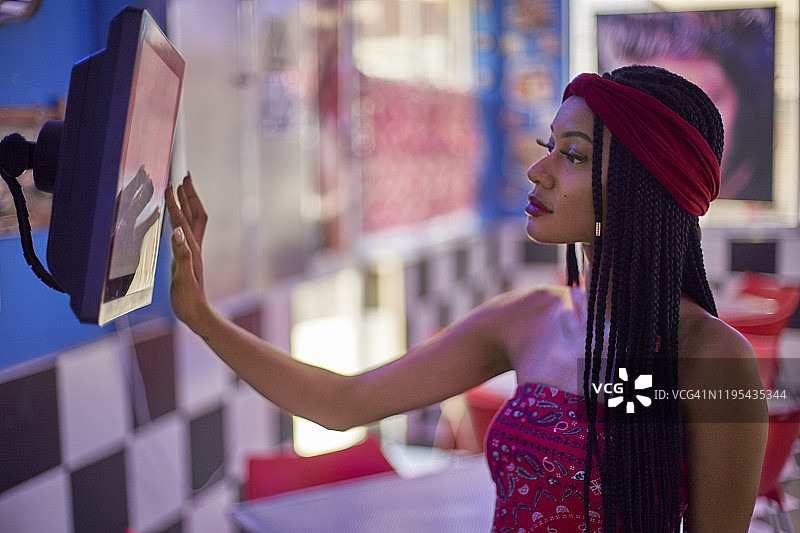 编发年轻女子正在触屏上查看订单图片素材