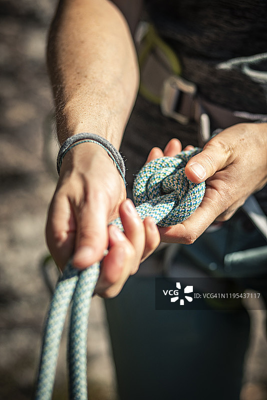 女人准备攀岩，检查绳索图片素材