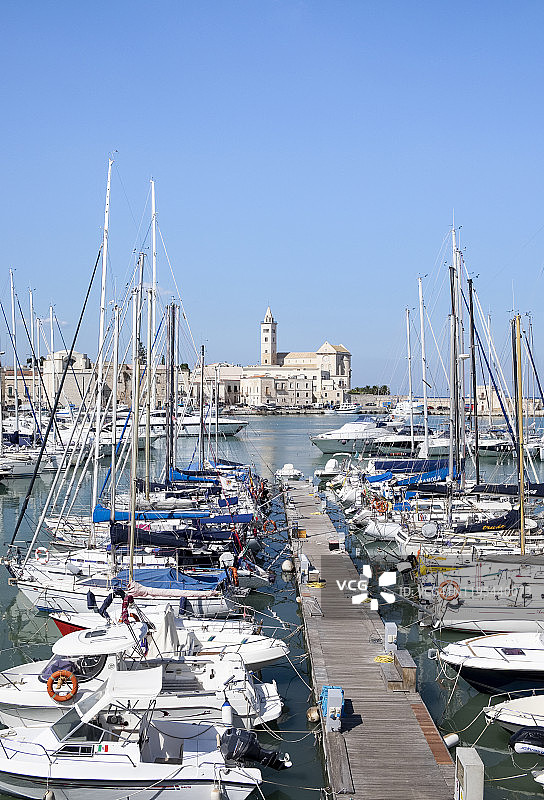 意大利普利亚特拉尼：停泊在码头的船只，背景是圣尼古拉佩莱格里诺大教堂图片素材