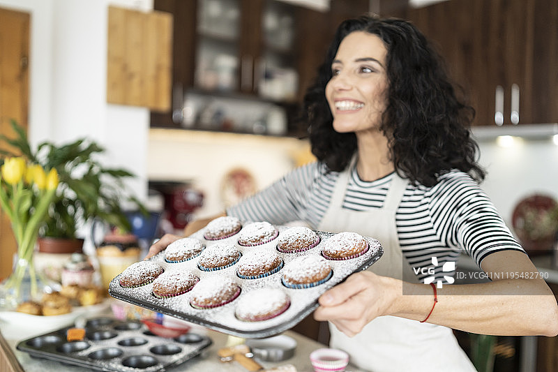 微笑的母亲和自制松饼的欢乐时光图片素材