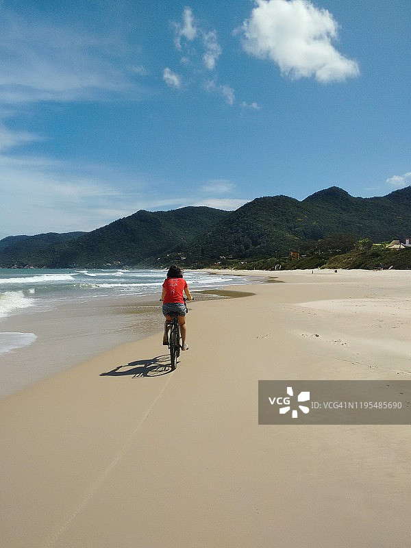 女孩在海滩上骑自行车图片素材