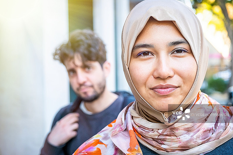 微笑的穆斯林亚洲女大学生和她的未婚夫图片素材