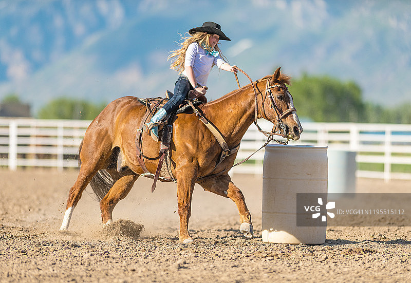 骑马绕桶赛的牛仔女郎图片素材