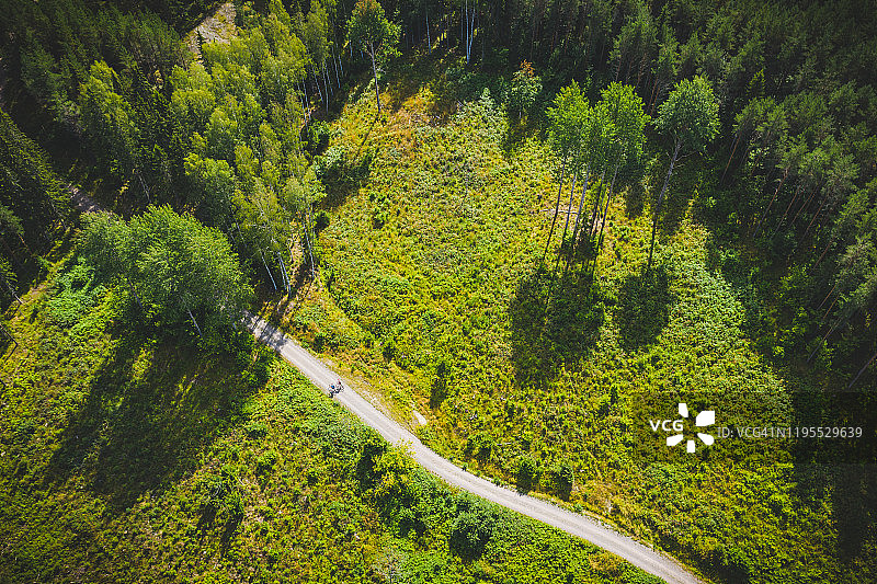 芬兰森林中土路上的两名骑自行车者航拍图片素材
