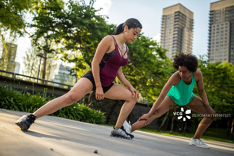 在公园里一起伸展身体的拉丁裔和非洲裔女性图片素材