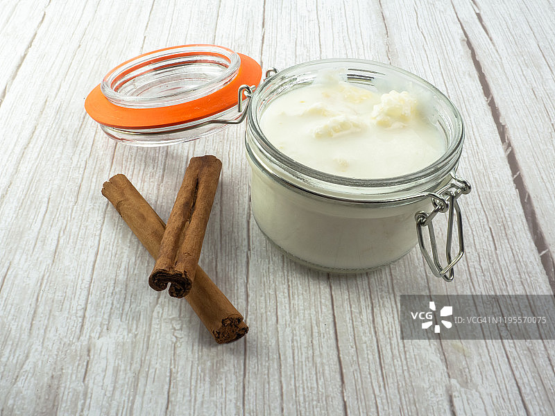 玻璃罐中的开菲尔菌和全脂牛奶及肉桂棒图片素材