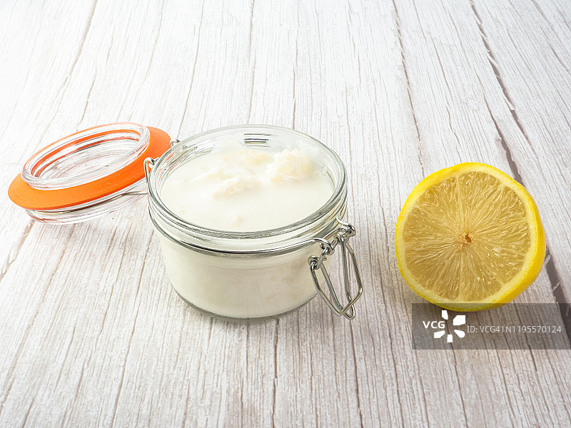 玻璃罐中的开菲尔菌和全脂牛奶，以及半个柠檬图片素材