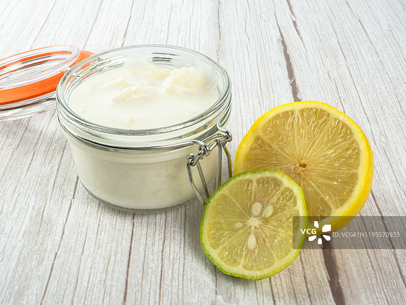 玻璃罐中的开菲尔菌和全脂牛奶，以及半个柠檬图片素材