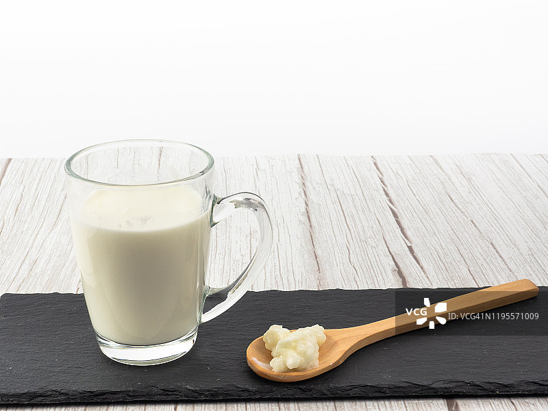 木勺中的开菲尔菌和玻璃杯中的全脂牛奶图片素材