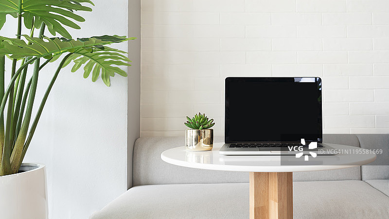 咖啡馆内桌面上带空白屏幕的笔记本电脑图片素材