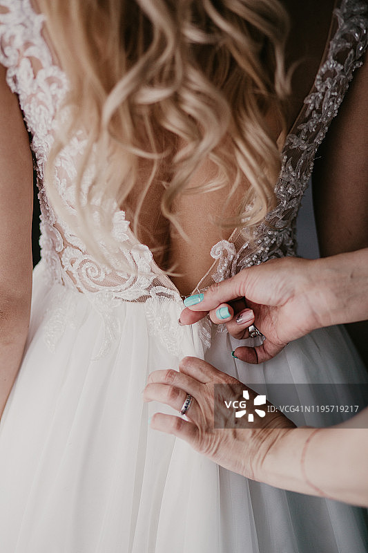 新娘准备：女人整理新娘礼服和头纱图片素材