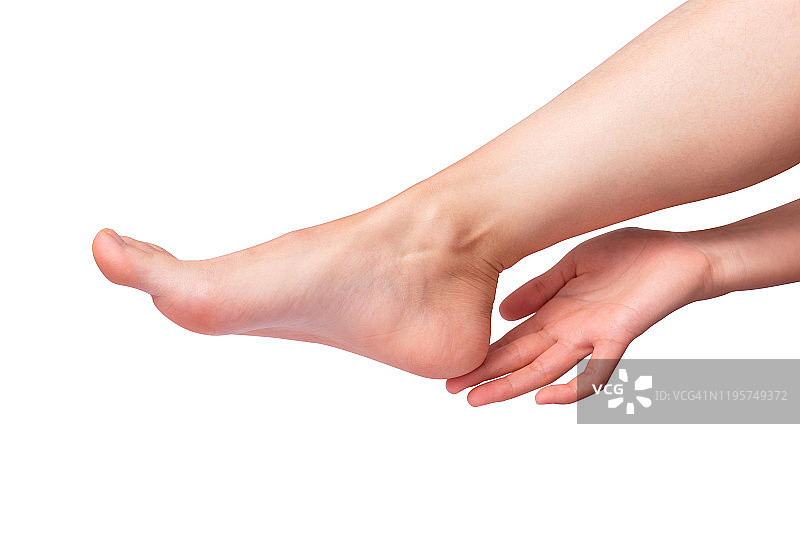 白色背景上完美的女性足部，手触碰优雅的腿，水疗足部护理概念图片素材