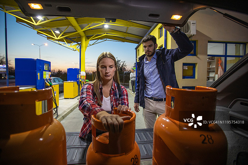 在加油站使用液化石油气罐的夫妇图片素材