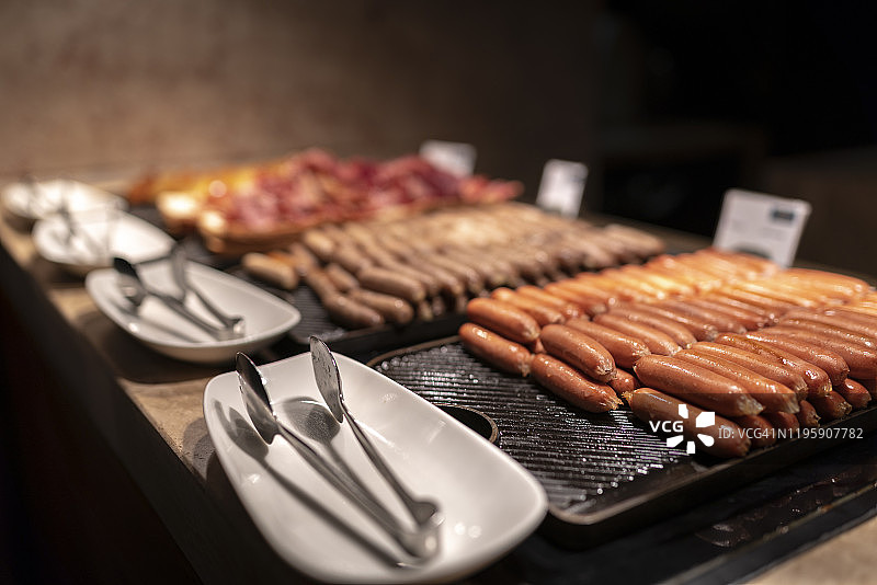自助餐餐具柜上的香肠和培根图片素材